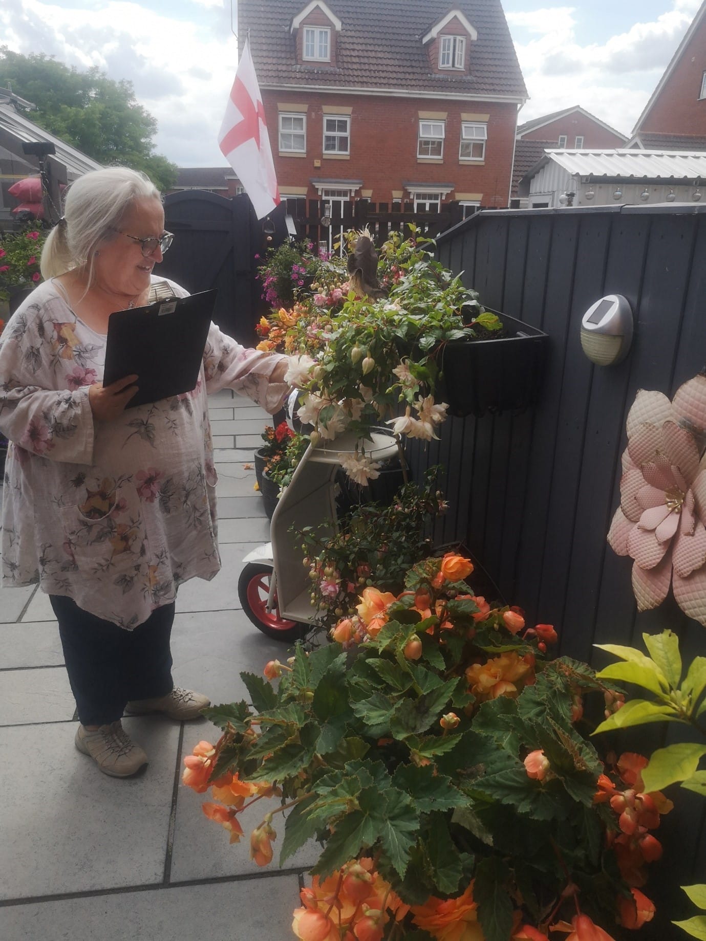 This photo shows Councillor Melanie Davis judging a residents garden for the Selby in Bloom competition